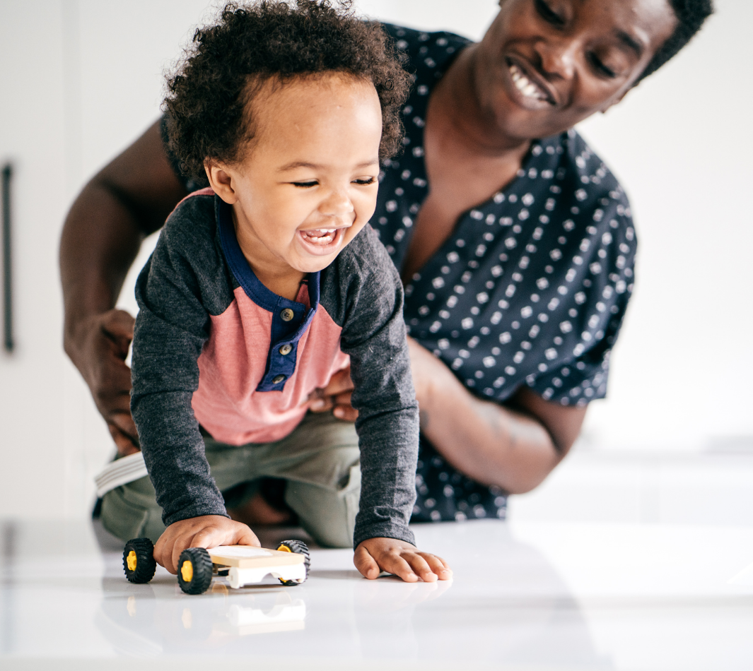 Child crawling with mom helping