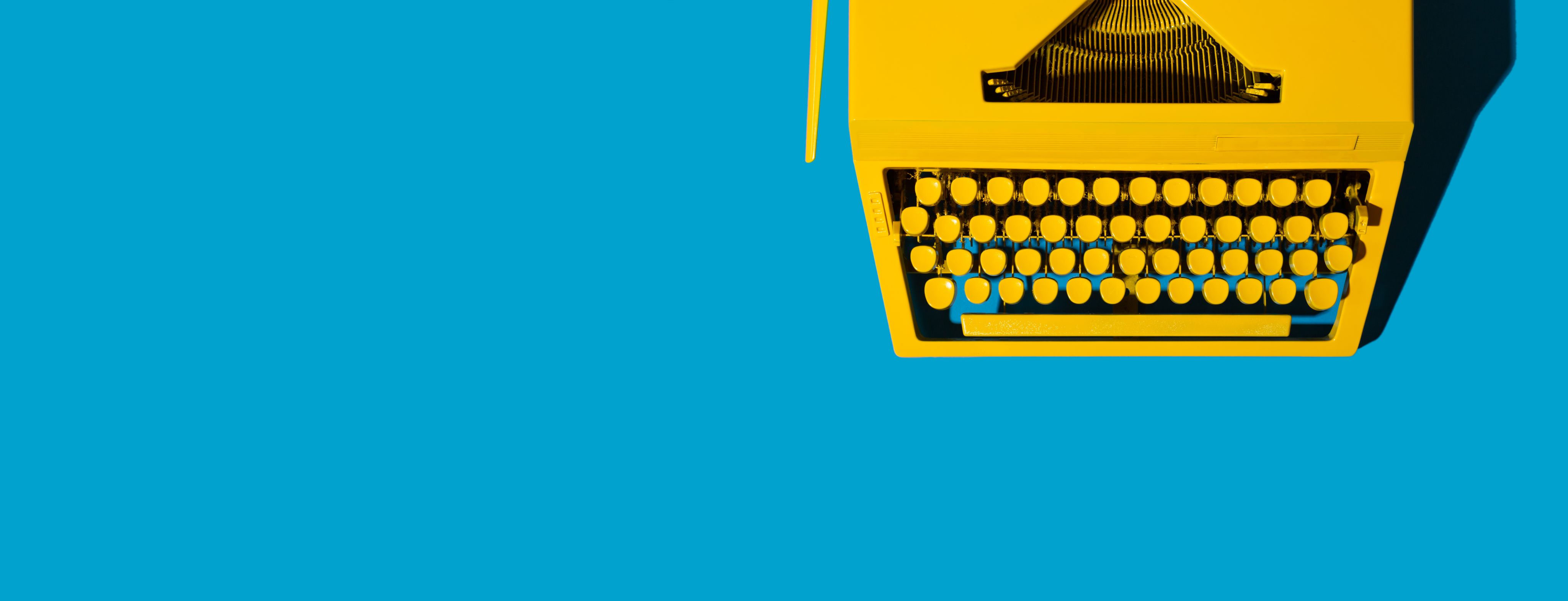 Bright blue background with a yellow typewriter