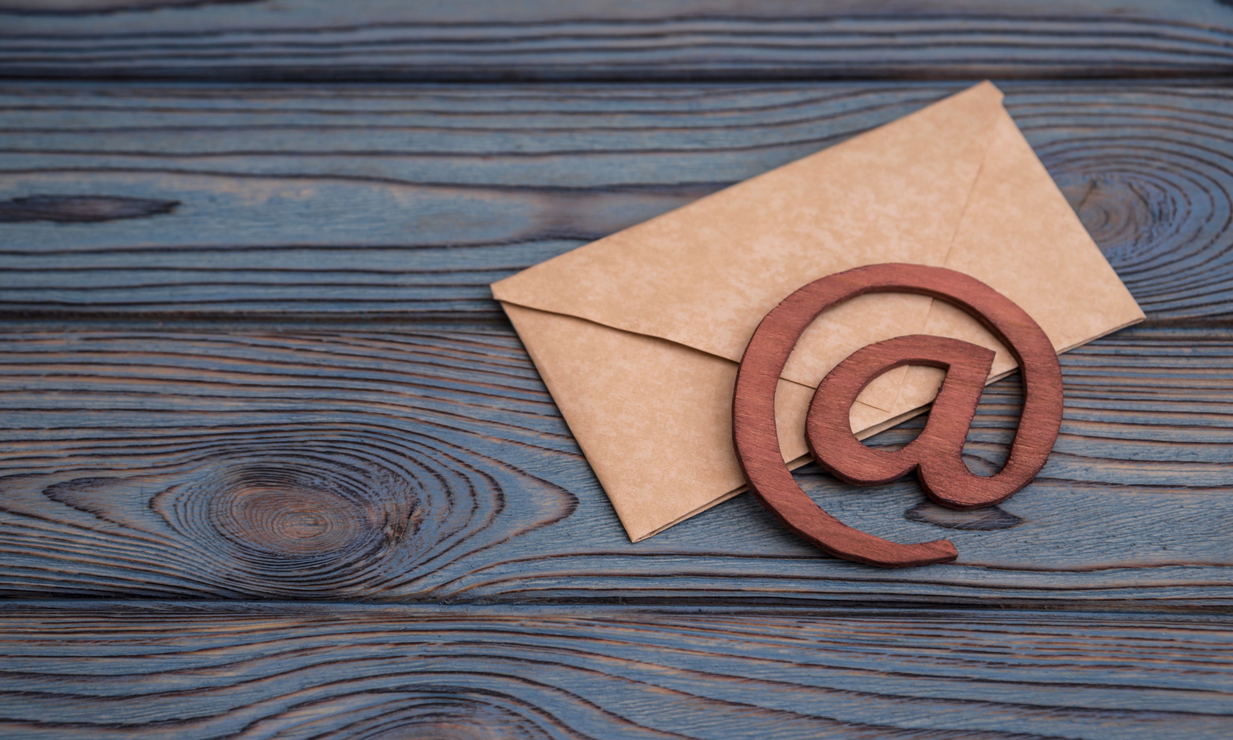 Wood background with a letter and @ symbol